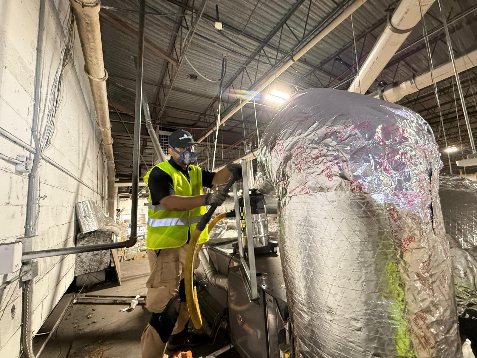 Industrial plant HEPA negative-air cleaning of large insulated flex duct on a production floor